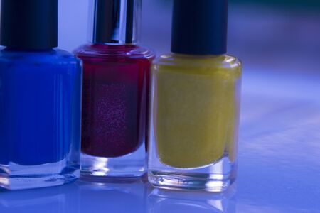 Close up of red lilac and yellow nail polish isolated.の写真素材