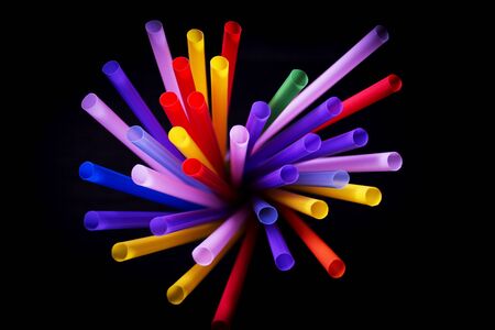 Drinking straws of all colors on black background.の写真素材