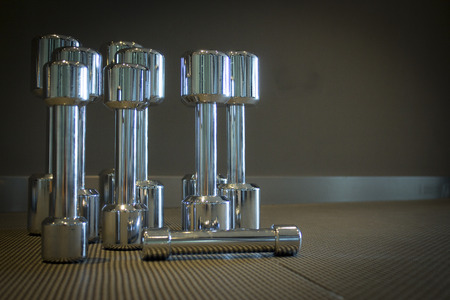 Row of steel dumbbells exercise on wood plank.の写真素材