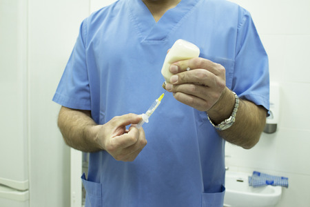 Veterinarian preparing syringe with medicine for petsの写真素材