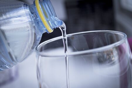 Serving water from a bottle to a glass