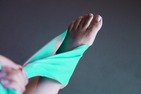 Woman's foot with elastic band performing stretching exercise
