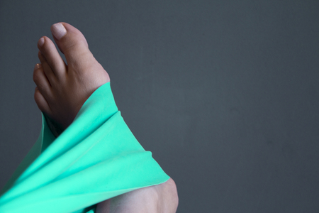 Woman's foot with elastic band performing stretching exerciseの写真素材