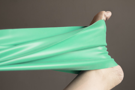 Woman's foot with elastic band performing stretching exerciseの写真素材