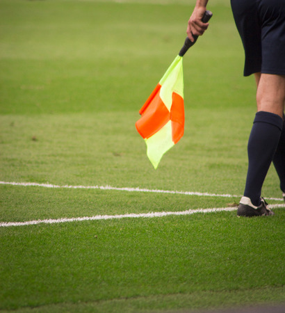 Soccer Referee with orange and yellow flagの写真素材