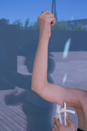 Part of the body of a woman measuring contour and body fatの写真素材