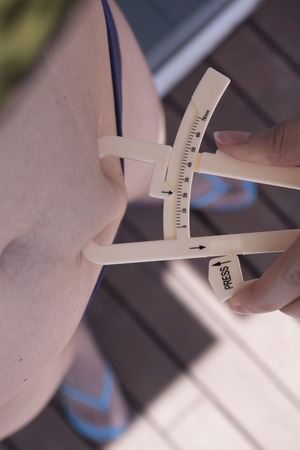 Part of the body of a woman measuring contour and body fatの写真素材