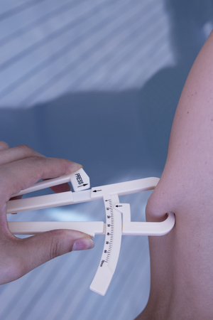 Part of the body of a woman measuring contour and body fatの写真素材