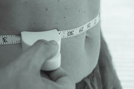 Body of a man measuring contour and body fat
