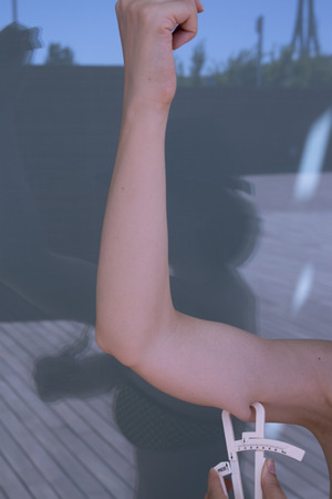 Part of the body of a woman measuring contour and body fatの写真素材