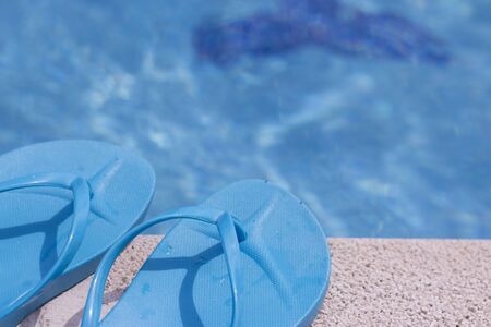 Summer shoes on the edge of a pool
