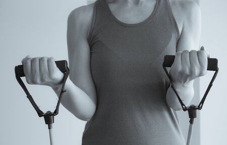 Girl doing gymnastic exercises with elastic resistance tubeの写真素材