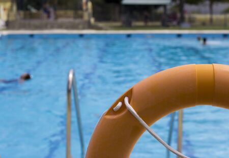 Orange life float. View of pool in the background unfocused.の写真素材