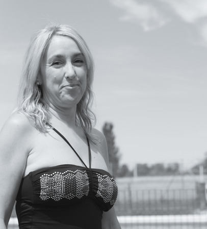 Portrait of blond woman with swimsuit and pool backgroundの写真素材