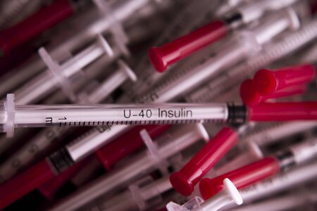 Insulin syringes on multicolored background out of focus
