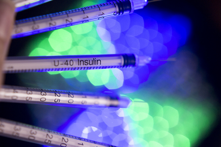 Insulin syringes on multicolored background out of focusの写真素材