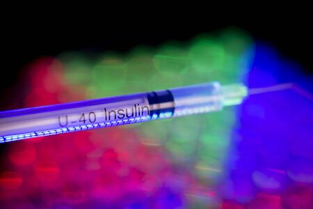 Insulin syringe on multicolored background out of focusの写真素材