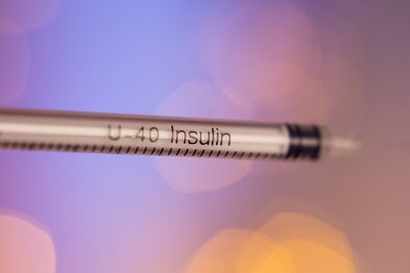 Insulin syringe on multicolored background out of focusの写真素材