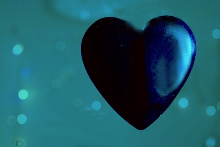 Blue transparent heart on color backgroundの写真素材