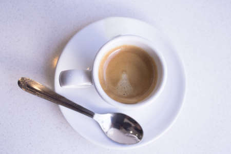 Cafeteria table with white cup of coffeeの写真素材