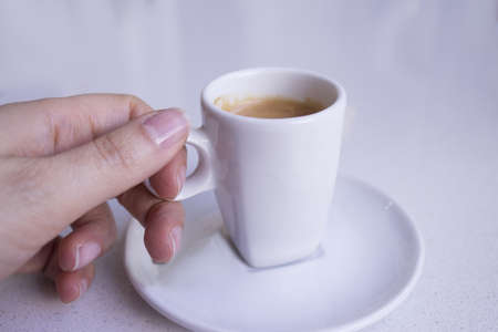 Cafeteria table with white cup of coffeeの写真素材