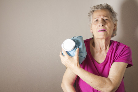 Ice pack on older woman arm to relieve painの写真素材
