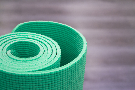 Yoga mat on wooden floor to perform meditation exercisesの写真素材