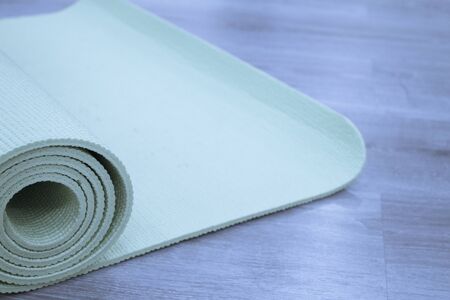 Yoga mat on wooden floor to perform meditation exercisesの写真素材