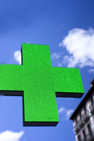 Sign in the shape of a cross indicating the existence of a pharmacyの写真素材