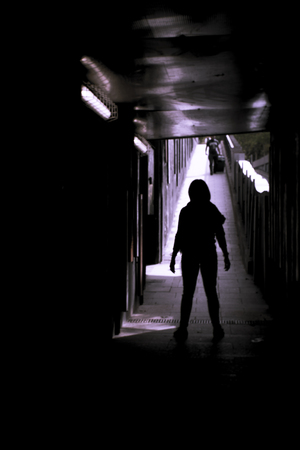 Woman alone and sad in a tunnel. Scene of mystery and desolationの写真素材