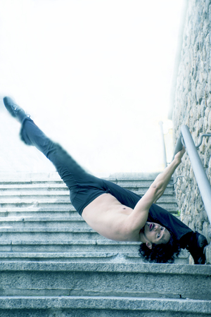 Male dancer doing a classic ballet pirouette. Urban background
