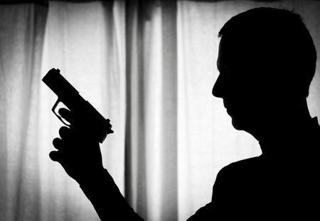 Man in a position of alert with a gun in his handの写真素材