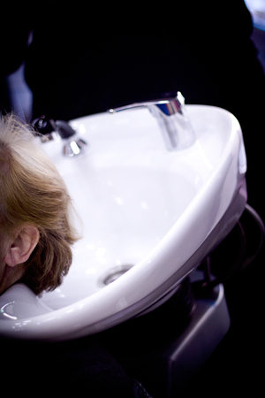 Hairdresser washing the head of a client. Hair not yet wetの写真素材