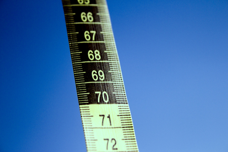 Measuring tape on blue background. No people