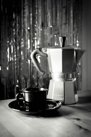 Cup of coffee next to classic Italian coffee makerの写真素材
