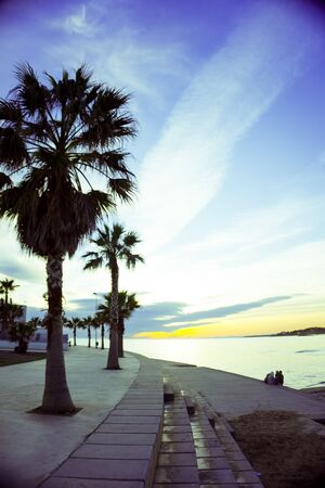 Beautiful sunset on the beach with palm trees. No peopleの写真素材