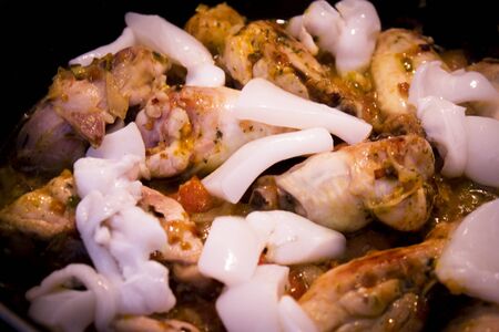 Vegetable stir fry with seafood and chicken to prepare paella. No people