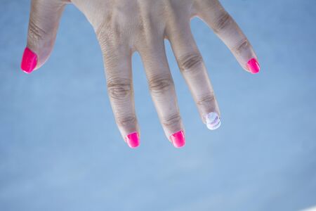 Womans hand showing her semipermanent manicure. Pink colourの写真素材