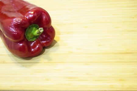 Raw ripe red pepper on cutting board. No people