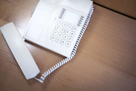 Classic telephone on top of the table in a hotel room. No people