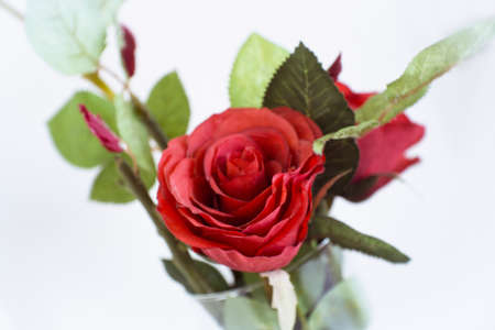 Artificial red roses inside a glass vase decorating hotel room. No peopleの写真素材