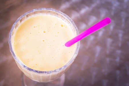 Glass bowl with fruit smoothie and drinking strawの写真素材