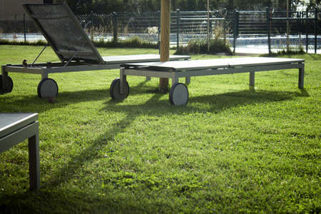 Sun loungers on the lawn. Straw umbrellas. No peopleの写真素材