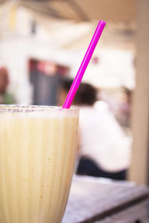 Glass bowl with fruit smoothie and drinking strawの写真素材