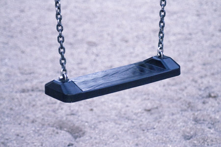 Wooden swing with metal chains for children. No people