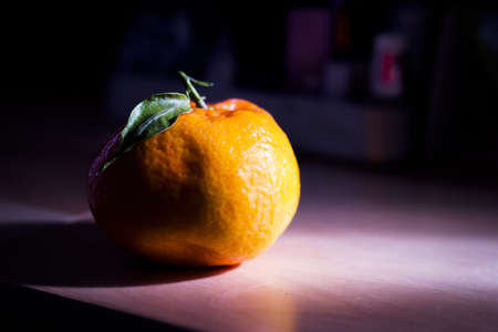Tangerine on wooden table with direct sunlight side light. Copy spaceの写真素材