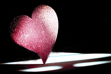 Golden shiny heart on black background