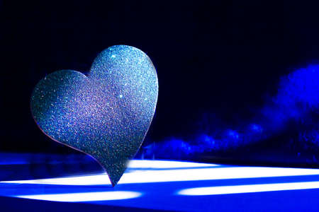 Golden shiny heart on black backgroundの写真素材