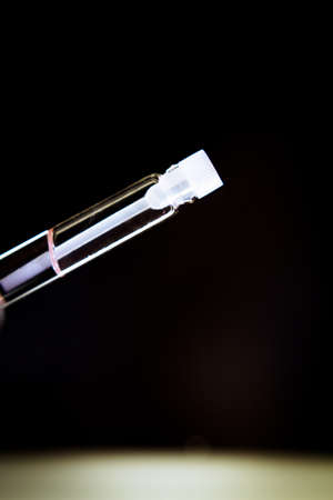 Perfume sample in a small clear glass bottle. Copy spaceの写真素材