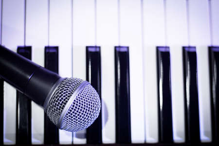 Microphone over piano keys in dim light. No peopleの写真素材